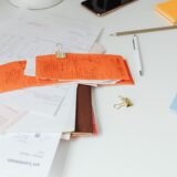 Dosar cu facturi neîncasate și documente contabile pe biroul unei firme creditoare