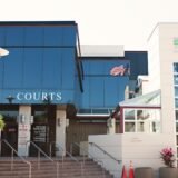 Intrarea unei clădiri de tribunal cu scări și coloane, unde se pot consulta dosarele aflate pe rol