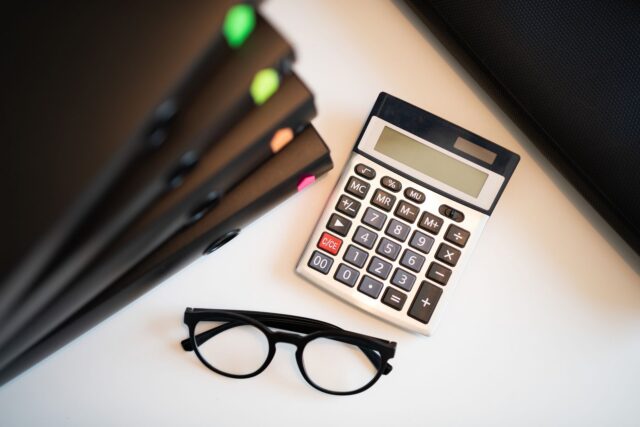 Documente de credit bancar, calculator și pix pe o masă, pregătite pentru compararea ofertelor