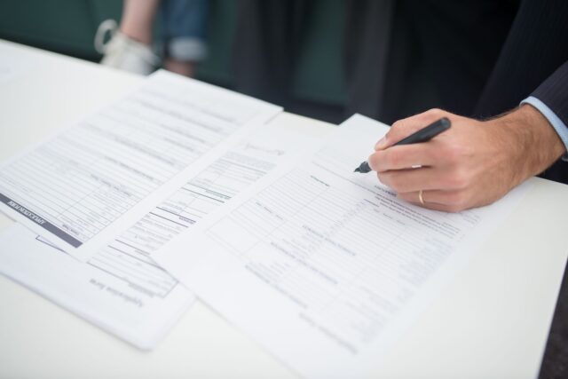 Cetățean care depune o petiție scrisă la ghișeul de registratură al unei instituții publice