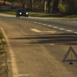 Mașini oprite pe marginea drumului după un accident minor, cu triunghi reflectorizant așezat în spate